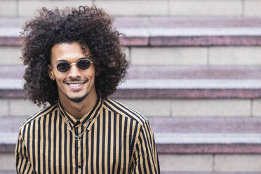 Handsome man wearing sunglasses in front of staircase - PNAF01286