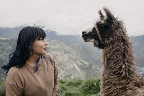 Woman with bangs looking at Alpaca - DSIF00390