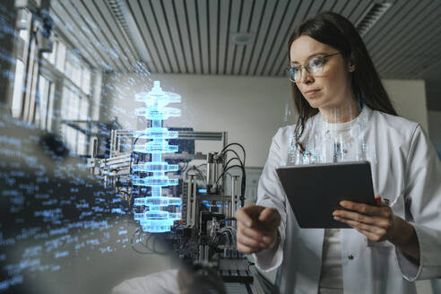 Female engineer with digital tablet examining development of industrial product - LIFIF00005