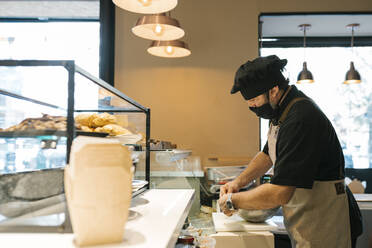 Männlicher Koch bei der Zubereitung von Speisen im Restaurant - EGAF02213