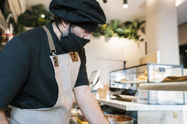 Älterer Mann bei der Arbeit in der Restaurantküche während COVID-19 - EGAF02214