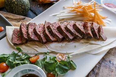 Veal meat served with radish and carrot on plate in restaurant - EGAF02235