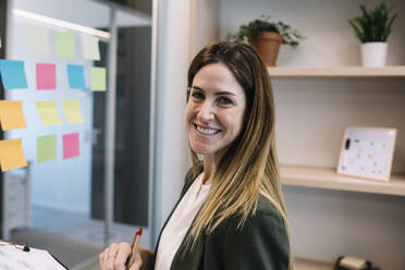 Confident businesswoman planning strategy at office - XLGF01420