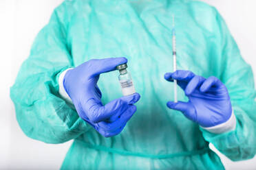 Hände eines Arztes mit Covid-19-Impfstoff und Spritze - RTBF01587