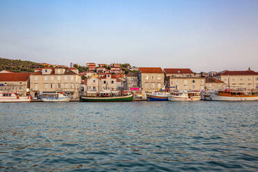 Kroatien, Gespanschaft Split-Dalmatien, Trogir, Boote an der Küste der Insel Ciovo mit Häusern im Hintergrund - MAMF01695