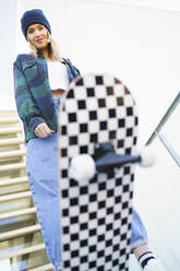 Young woman doing stunt on skateboard - JSMF02086