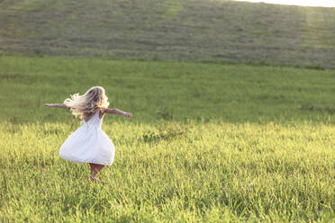 Blond girl dancing on meadow during sunset - WFF00526