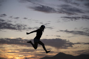 Aufgeregte Frau springt bei Sonnenuntergang - SNF01221