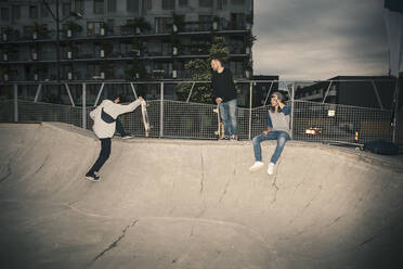 Männliche Freunde im Skateboardpark in der Abenddämmerung - MASF22519