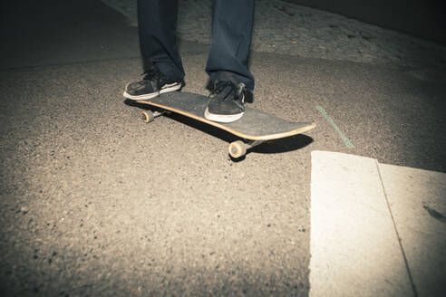 Männlicher Skater auf einem Skateboard auf dem Gehweg stehend - MASF22522