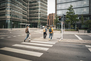 Rückansicht von männlichen Freunden beim Überqueren der Straße in der Stadt - MASF22555