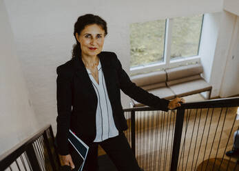 Portrait of female entrepreneur standing on steps at office - MASF22659