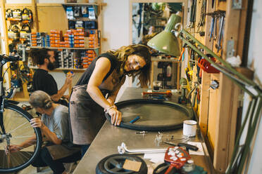 Männliche und weibliche Mechaniker reparieren ein Fahrrad in einer Werkstatt - MASF22726