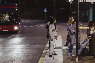 Freundinnen sitzen nachts an der Bushaltestelle - MASF22742