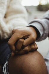 Cropped image of female teenager friends holding hands outdoors - MASF22768