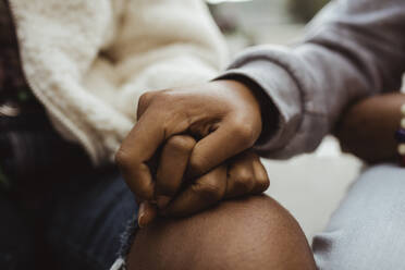 Cropped image of female friends holding hands outdoors - MASF22770