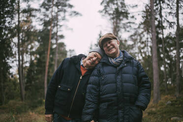 Porträt eines lächelnden schwulen Paares im Wald stehend - MASF22833