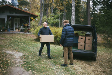 Homosexual couple loading boxes while relocating in house - MASF22862