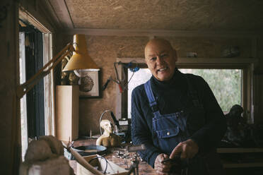 Porträt eines lächelnden schwulen Mannes in einer Werkstatt - MASF22870