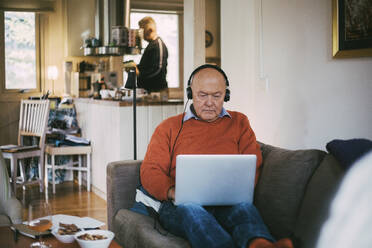 Senior gay man using laptop while sitting at home - MASF22883