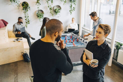 Männliche und weibliche Kollegen unterhalten sich in der Pause im Büro miteinander - MASF22929