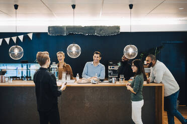 Geschäftsleute diskutieren am Tisch in der Cafeteria im Büro - MASF22967