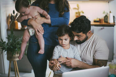 Children and parents taking online advice on video call through laptop at home - MASF23015