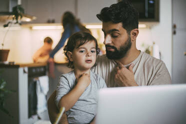Father and son taking online advice through laptop at home - MASF23017