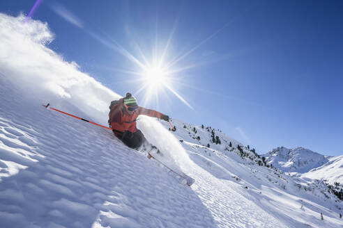 Sonnenschein über einem Mann beim Skifahren im Arlberg-Massiv - RNF01303