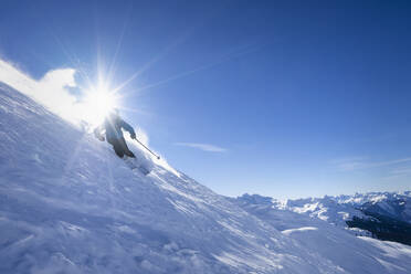 Sonnenschein über einem Mann beim Skifahren im Arlberg-Massiv - RNF01305