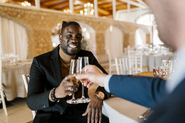 Elegante Männer sitzen beim Bankett und stoßen mit Champagner an - EGAF02269