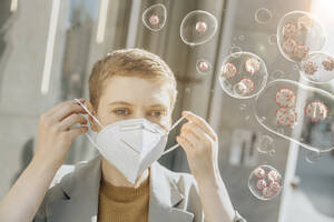 Woman putting in face mask to protect herself from corona viruses - LIFIF00009