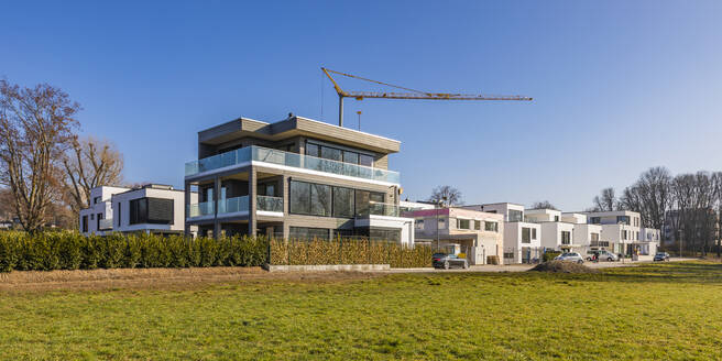 Deutschland, Baden-Württemberg, Ludwigsburg, Panorama von klarem Himmel über modernem Neubaugebiet mit Industriekran im Hintergrund - WDF06564