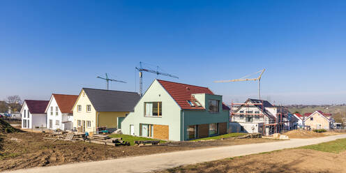 Deutschland, Baden-Württemberg, Ludwigsburg, Panorama eines klaren Himmels über einem modernen Neubaugebiet mit Industriekränen im Hintergrund - WDF06566