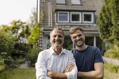 Cheerful father and son standing in backyard - GUSF05600