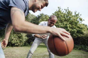 Vater betrachtet Basketball, den sein Sohn im Hinterhof hält - GUSF05672
