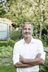 Confident man with arms crossed during sunny day - GUSF05707