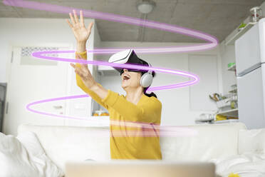 Spiralförmiges Design um eine überraschte Frau, die zu Hause ein Virtual-Reality-Headset trägt - JCCMF01645