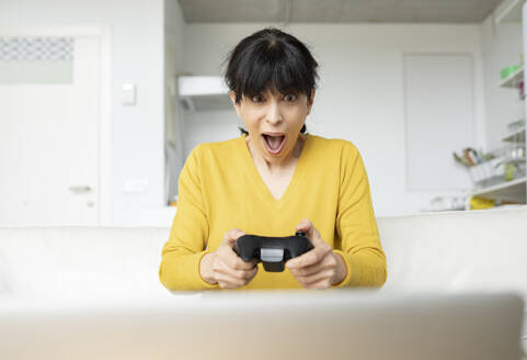 Überrascht Frau spielt Videospiel zu Hause - JCCMF01648