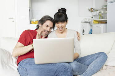 Ehepaar während eines Videogesprächs auf dem Laptop zu Hause - JCCMF01655