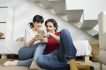Pärchen diskutiert über Smartphone, während es zu Hause sitzt - JCCMF01661