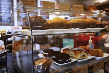 Ausgestellte Kuchen und Muffins in der Bäckerei - AZF00221