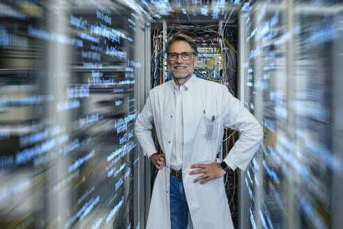 Server technician wearing lab coat standing amidst algorithms at data center - LIFIF00012