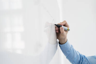 Hand of male professional writing on whiteboard at office - DIGF14950