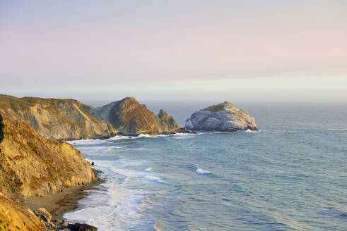 USA, California, Big Sur, Picturesque coastal landscape with San Martin Rock at sunset - BRF01520