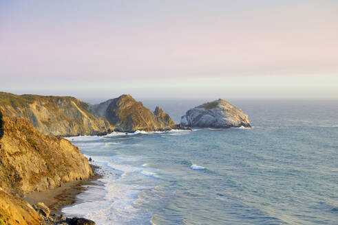 USA, Kalifornien, Big Sur, Malerische Küstenlandschaft mit San Martin Rock bei Sonnenuntergang - BRF01520