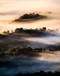 Spektakuläre Landschaft von flauschigen Wolken schweben über Berge mit üppigen Bäumen in sonnigen Morgen bedeckt - ADSF22432