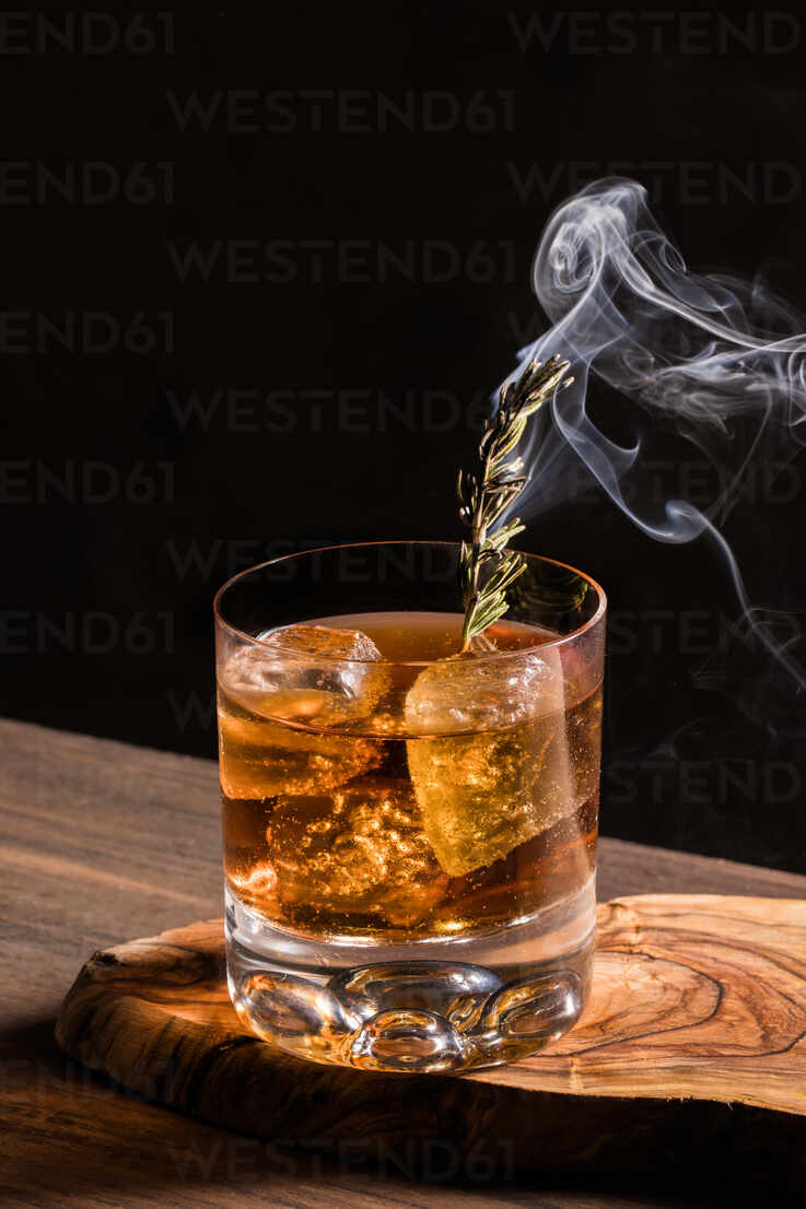 Crystal whiskey glass with ice cubes on a wooden table. Stock