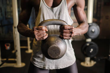 Männlicher Athlet hebt Kettlebell im Fitnessstudio - AODF00435