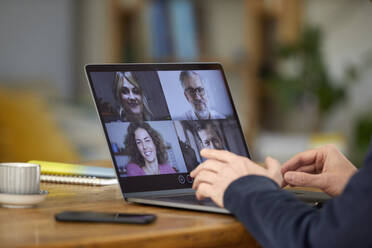 Businessman discussing on video call with colleagues through laptop over table - PSBHF00002